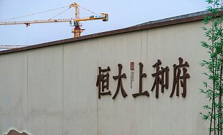 Ein Baukran steht auf einem neuen Wohnbauprojekt von Evergrande in Peking. - Foto: Andy Wong/AP/dpa