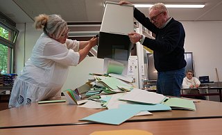 Sabine Nordmann und Burkhard Wehmeyer leeren die Wahlurne im Wahllokal 060 in der Realschule Enger. Beide engagieren sich seit über 20 Jahren als Wahlhelfer. - Juri Bürgin