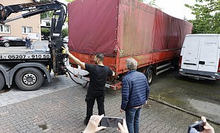 Auch der große rote Iveco-Laster mit Aufleger wird abtransportiert. Auf der Ladefläche unter der Plane stehen ein Mercedes und ein Citroën - auch sie wurden mitgenommen. - Privat