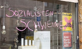 Schmierereien an der Schaufensterscheibe eines Geschäfts in Bielefelds Altstadt. Die Besitzein hat ein „Rote Karte für AfD"-Plakat im Fenster. - Oliver Krato