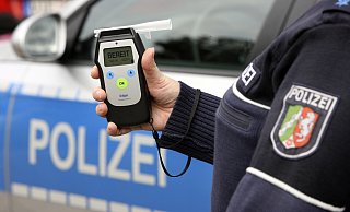 Symbolbild: Ein Beamter zeigt ein Messgerät für Alkohol. - Jochen Tack