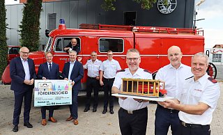 Ein Modell der verglasten Oldtimer-Garage zeigt (vorne, v. l.) Feuerwehrfördervereinschef Thomas Westhof mit seinen Stellvertretern Hans-Georg Liemke und Udo Plaßhenrich. Auf die Umsetzung freuen sich (hinten, v. l.) der Landtagsabgeordnete Bernhard Hoppe-Biermeyer, Staatssekretär Daniel Sieveke, Bürgermeister Michael Berens, LF8-Gerätewart Dirk Boskamp, Historienbeauftragter Michael Kesselmeier und Wehrleiter Sebastian Lienen. - Gemeinde Hövelhof Ein Modell der verglasten Oldtimer-Garage zeigt (vorne, v. l.) Feuerwehrfördervereinschef Thomas Westhof mit seinen Stellvertretern Hans-Georg Liemke und Udo Plaßhenrich. Auf die Umsetzung freuen sich (hinten, v. l.) der Landtagsabgeordnete Bernhard Hoppe-Biermeyer, Staatssekretär Daniel Sieveke, Bürgermeister Michael Berens, LF8-Gerätewart Dirk Boskamp, Historienbeauftragter Michael Kesselmeier und Wehrleiter Sebastian Lienen. - Gemeinde Hövelhof