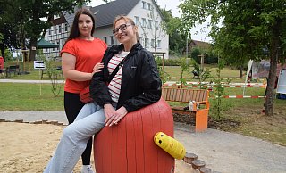 Zwei Besucherinnen haben auf einem der ungewöhnlichen Sitzmöbel auf dem Spielplatz Platz genommen. - Mareike Patock