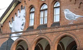 Ein Sänger des Knabenchores und eine Nachtigall prangen an der Fassade des Konfirmandenhauses in der Kirchstraße in Gütersloh. - Tschackert/Osterkamp Ein Sänger des Knabenchores und eine Nachtigall prangen an der Fassade des Konfirmandenhauses in der Kirchstraße in Gütersloh. - Tschackert/Osterkamp