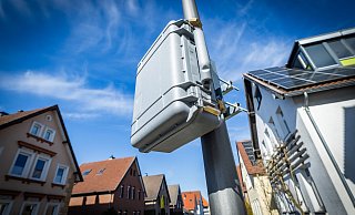 Kleine, dicke hellgraue Koffer hängen an diversen Stellen in Bielefeld an Laternenmasten. Die darin erhobenen Messdaten sollen der Stadt bei wichtigen Planungen helfen. - Sarah Jonek