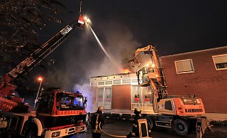 Kurz nach 17 Uhr ist ein großer Bagger mit Greifer eingetroffen. Damit hat die Feuerwehr die Dachhaut geöffnet, um an den Brandherd zu kommen. - David Schellenberg