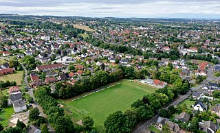 Schön gelegen: Der Westerfeld-Sportplatz in der Südstadt Bad Oeynhausens. An der Stirnseite sind sowohl das Schützenhaus (rechts, rotes Dach) als auch das neue Vereinsheim des TuS Bad Oeynhausen (weiß/grau) zu sehen. Parkplätze gibt es hier allerdings kaum. - Jürgen Krüger