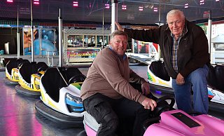 Alfred (85) und Dirk (56) Küchenmeister zusammen am Autoscooter. Das Fahrgeschäft ist der ganze Stolz der Schaustellerfamilie. - Veronika Kinsfator