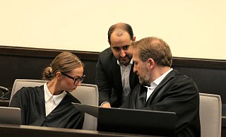 Zum Auftakt des Verfahrens besprechen sich die Verteidiger Lena Holtkötter und Maximilian Steinert (r.) mit einem der Übersetzer. - Rajkumar Mukherjee