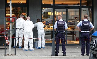 Spurensicherung und Polizei stehen der Bäckerei an der Hauptstraße, in die das blutüberströmte Opfer aus Angst vor seinem Verfolger gestürmt war. - Paul Brinkmann