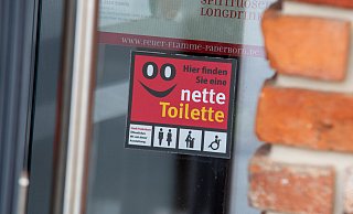 Dieser Aufkleber verweist auf die Aktion "Nette Toilette" am Eingang des Restaurants Feuer & Flamme in Paderborn. - Niklas Tüns