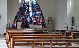 Der Kirchenraum in Calenberg ist verschlossen, gewährt aber einen Blick durch die seitliche Glastür ins Innere mit Ambo, Altar und Tabernakel. - Simone Flörke