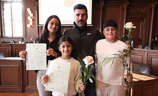 Haifa Jirdo (l.) und ihr Mann Omer Alyas mit ihren beiden Kindern. Gemeinsam mit ihrer Tochter nahm die aus dem Irak stammende Frau die Einbürgerungsurkunde entgegen. - Björn Kenter