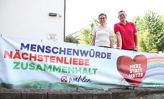 Die Preußisch Olderdorfer Pfarrerin Hilke Vollert und Pfarrer Steffen Bäcker werben unter anderem am Gemeindehaus in Bad Holzhausen für Menschenwürde, Nächstenliebe und Zusammenhalt. - Frank Hartmann