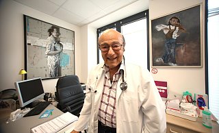 Der Paderborner Basem Al-Ghoul liebt seine Arbeit als Internist, wie er sagt. Im Hintergrund sind in seiner Praxis Bilder seiner Ehefrau Renata zu sehen. - Rajkumar Mukherjee