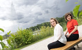 Die Kuratorinnen Marijke Lukowicz (l.) und Sophia Trollmann sitzen am Padersee. Beim Sich-Hinsetzen auf diese Bank schießt eine 20 Meter hohe Fontäne in die Höhe: Es ist die Arbeit von Jeppe Hein, die auch künftig für Interaktionskunst sorgen könnte. - Niklas Tüns
