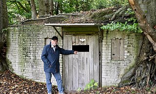 Georg Terlutter steht vor dem Eingang des versteckten Objektes im Kreis Gütersloh, das aussieht wie eine Erdbehausung der Hobbits. - Neue Westfälische