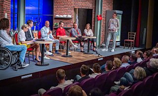 Wo aktuell eigentlich Jochen Busse in "Weiße Turnschuhe" auf der Bühne steht, diskutierten (v.l.) Florian Sander (AfD), Christiana Bauer (CDU), Dominic Hallau (Grüne), Ingo Nürnberger (SPD), Onur Ocak (Die Linke), Lena Oberbäumer (Die Partei), Jasmin Wahl-Schwentker (FDP) und Moderator Timo Fratz. - Sarah Jonek