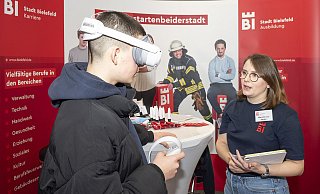 Per VR-Brille als Kfz-Mechatroniker unters Auto: Marie-Kristin Janzen lässt Schüler am Stand der Stadt in die Berufswelt eintauchen. - Dieckmann-Fotodesign l Bielefeld