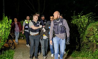 Einsatzkräfte der Polizei führen den Tatverdächtigen nach seiner Festnahme ab. - Tim Oelbermann/dpa