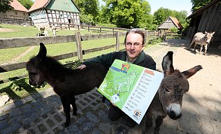 Tierparkleiter Herbert Linnemann präsentiert das Hinweisschild, das die Besucher auch als Infoflyer am Eingang bekommen. Die neugierigen Zwergesel-Fohlen Johanna (links, am 10. April geboren) und Liesel (geboren am 26. April) wollten auch mit aufs Bild. - Wolfgang Rudolf