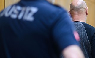 Der angeklagte Bielefelder kommt in den Gerichtssaal im Landgericht Hannover. Der Mann soll im Juli 2021 im Stadtpark Eilenriede in Hannover einen auf einer Parkbank sitzenden Obdachlosen getötet haben. - Julian Stratenschulte/dpa