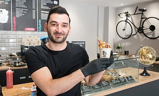 Gökay Celik, Inhaber der Yogurt-Bar Cheaty, zeigt eine seiner Bubble-Waffles, eine besonders lockere Waffelvariante mit Eis, Saucen und Toppings. - Ralf Bittner