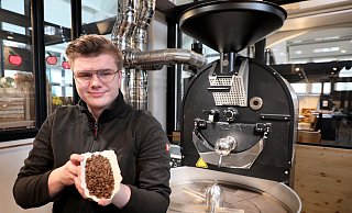 Juniorchef Moritz Stecker röstet schonend Bio-Kaffeebohnen in der Röstmaschine am Stand in der Markthalle. - Frank-Michael Kiel-Steinkamp