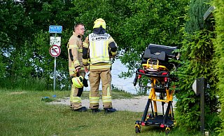 Einsatzkräfte der Paderborner Feuerwehr warten in Ufernähe, während Notarzt und Notfallsanitäter um das Leben des verunfallten Mannes kämpfen. - Ralph Meyer