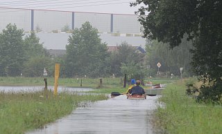 Auf den überfluteten Wiesen unweit des Rila-Hochregallagers und auf dem überschwemmten Radweg an der Schröttinghauser Straße waren nach dem Regen-Untwetter vom 16. August 2015 zwei Kanufahrer unterwegs. - Joern Spreen-Ledebur