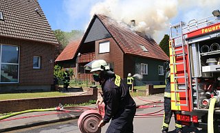 Rauch dringt aus dem Dach des Einfamilienhauses. - Ekkehard Wind