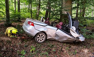 An zwei Bäumen zerschellt: Der Fahrer des VW Eos Cabrio war auf der Stelle tot. Vize-Wehrführer Michael Stork untersucht das Wrack. - Ralph Meyer
