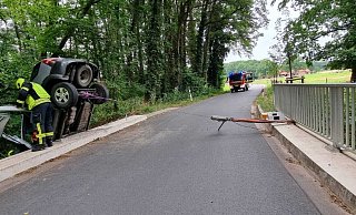 Mit einem Hebelzug sicherte die Feuerwehr Borgholzhausen den Kia Sorento. Später zog ein Abschleppunternehmer den Wagen mittels Lkw-Kran zurück auf die Straße. - Feuerwehr Borgholzhausen