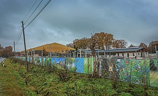 Hinter dem bunten Bauzaun mit Naturbildern schlummert die Baustelle der geplanten SL Riding Ranch. Ob der generelle Baustopp bestehen bleibt oder aufgehoben wird, darüber entscheiden die Richter am Verwaltungsgericht Minden. - Sarah Jonek