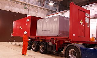 Ein sogenannter Konradcontainer mit Atommüll wird in einem roten Transportcontainer verstaut und dann per Lkw abgefahren. Die Anlieferung im geplanten Logistikzentrum Würgassen soll zum Teil über die Straße ablaufen. - BGZ