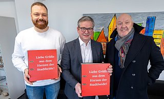 Marcel Döveling (l., Rewe) und Karl Förster (r., Heide-Center) überreichen die Ordner mit den Unterschriften, die sich gegen das Nahversorgungszentrum richten, an Paderborns Bürgermeister Michael Dreier. - Niklas Tüns