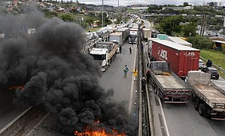 Anhänger des ehemaligen brasilianischen Präsidenten Bolsonaro blockieren eine Autobahn bei Itaborai. - Andre Penner/AP/dpa