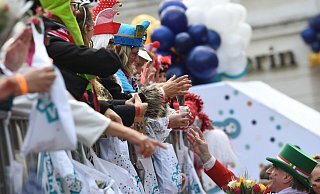 Karnevalisten auf dem Wagen verteilen beim Kölner Rosenmontagszug Kamelle und Blumensträuße (Strüßjer) - doch wie umweltfreundlich sind eigentlich die Verpackungen? - Federico Gambarini/dpa