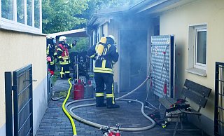 Salzkottener Feuerwehrleute bergen Gasflaschen aus der brennenden Werkstatt. - Ralph Meyer