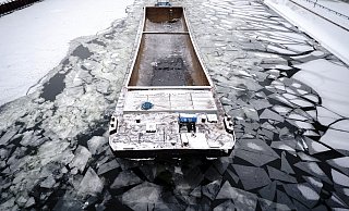 Ein Schubverband bahnt sich bei frostigen Temperaturen den Weg durch das Eis auf der Spree im Berliner Regierungsviertel. - picture alliance/dpa