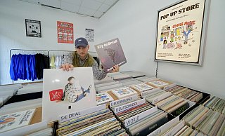 Lutz Reineke in seinem neuen Pop-Up-Store für Schallplatten und Mode. Hier zeigt der 23-Jährige eine der Raritäten - und vorne seine eigene, neueste Platte. - Peter Unger