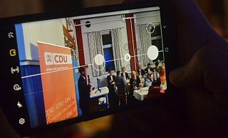 Ein Parteimitglied filmt per Smartphone die Rede des CDU-Stadtverbandsvorsitzenden Daniel Sieveke (l.) beim Politischen Aschermittwoch. - Dietmar Gröbing