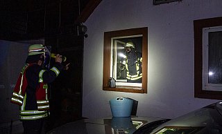 Zwei Feuerwehrmänner untersuchen das Brandhaus. - Michael Horst/Feuerwehr Porta