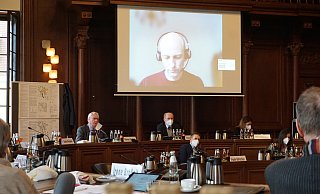 Der Leiter des Bahnprojekts Hannover-Bielefeld, Carsten-Alexander Müller, ist dem Rat per Livestream zugeschaltet. Werner Seeger (CDU) stellt ihm Fragen zur geplanten Trasse. - Christina Römer