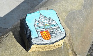 Künstler Egon Hüls hat auf einem historischen Pflasterstein das Paderborner Rathaus verewigt. - Stadt Paderborn
