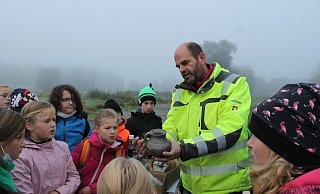 Dieser Fund vom Acker könnte ein Henkel gewesen sein – erklärt der Landesgartenschau-Archäologe Ralf Mahytka den Vierklässlern aus Ottbergen. - LGS 2023 Höxter/Manuela Puls