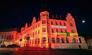 In Bielefeld erstrahlten am Aktionstag 29 Gebäude, hier der Bielefelder Hof, im satten Orange – die Farbe steht symbolisch für eine hellere Zukunft. - Mike-Dennis Müller / www.mdm.photo