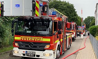 Schlange stehende Feuerwehrwagen beim Einsatz in der schmalen Straße Am Kamphof. - Stefan Becker