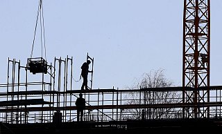 Handwerker arbeiten am Neubau eines Mehrfamilienhauses an einem Baugerüst. Der Staat will Neubauten fördern. - Karl-Josef Hildenbrand/dpa