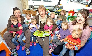 NW-Mitarbeiterin Karin Prignitz (Mitte) hat sich das Buch mit den Glitzersteinen ausgesucht, um es den Ein- bis Zweijährigen zu zeigen. V.l. Amelie-Sophie (2), Erzieherin Yvonne Kleinehagenbrock, Luca (2), Mia (2), Melissa (2), Ludwig (1), Julian (2), Talina (2), Erzieherin Nina Fattahov und Hanna (2). - FOTO: BESIM MAZHIQI